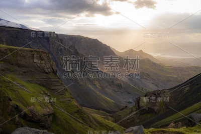 在Thorsmork附近的Fimmvorduhals徒步旅行步道上，峡谷和山顶在戏剧性和多彩的日落