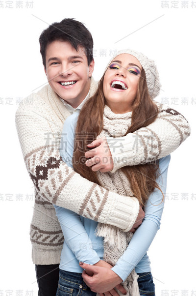 年轻微笑的夫妇在冬天的衣服拥抱