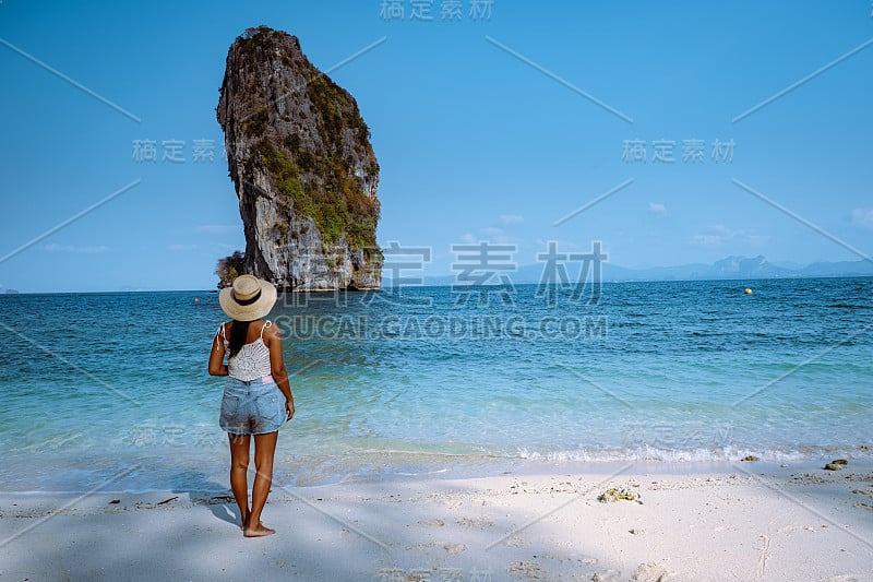 泰国Koh Poda Krab，一名戴着帽子的妇女在一个晴朗的日子与蓝天的Koh Poda岛的海滩上