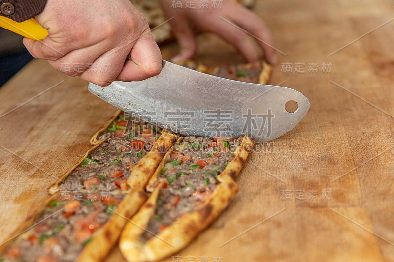 皮塔饼师傅准备好皮塔饼并把它扔进烤箱。