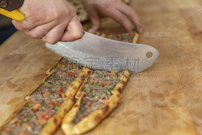 皮塔饼师傅准备好皮塔饼并把它扔进烤箱。