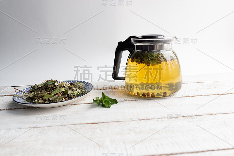 玻璃茶壶与冲泡森林草药在乡村木质背景