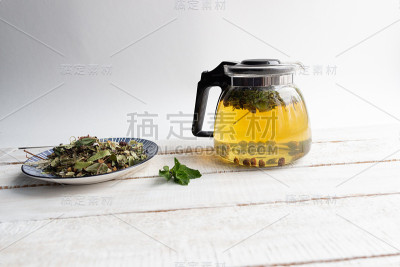 玻璃茶壶与冲泡森林草药在乡村木质背景
