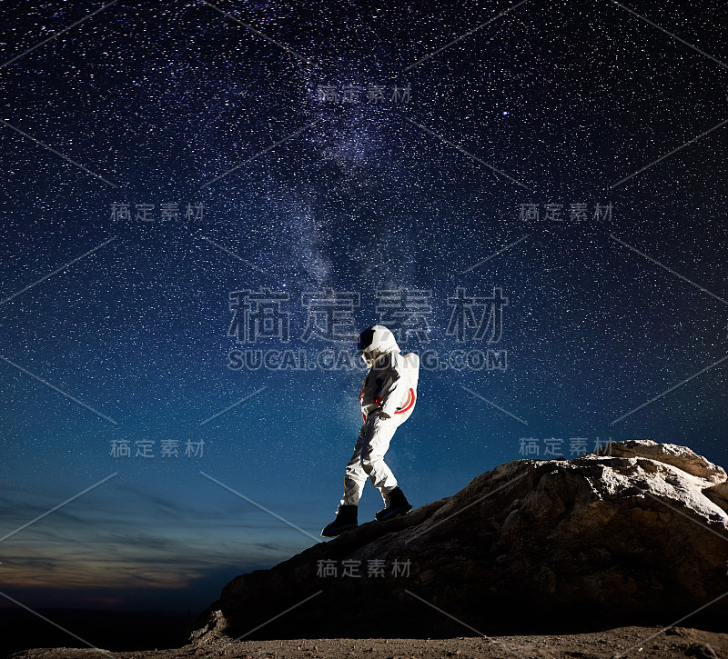 太空旅行者在星空下走下山。