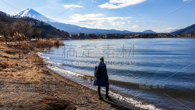 日本——一名女子站在川口町湖边，眺望富士山