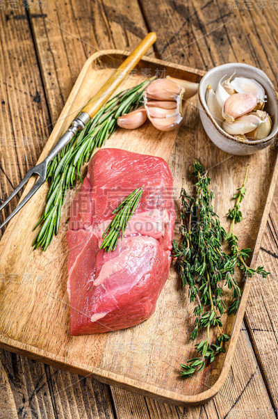 新鲜的小牛肉牛排配香草。木制背景。俯视图