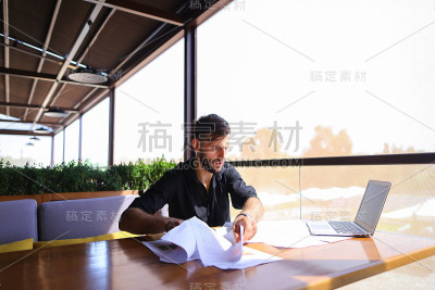 办公室职员在笔记本电脑旁边的桌子上整理文件