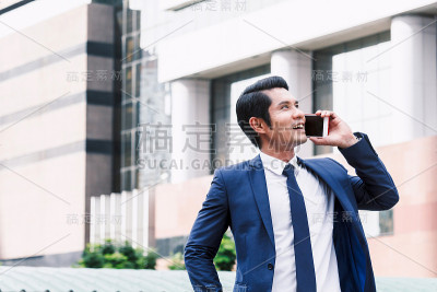 英俊的商人使用他的智能手机