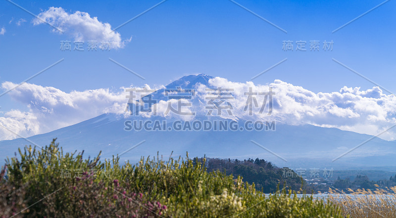 富士山美丽的全貌，山顶被雪和云覆盖。