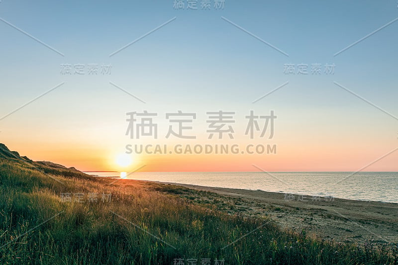 日落时的青山和沙滩。夕阳西下的黄昏海景。Peresyp度假村，克拉斯诺达尔地区，俄罗斯。