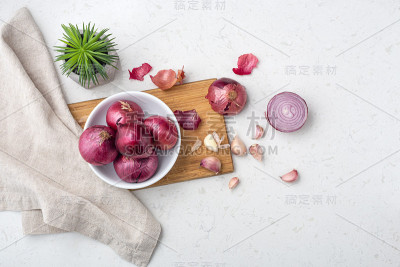 青葱和大蒜放在切菜板上，大理石背景