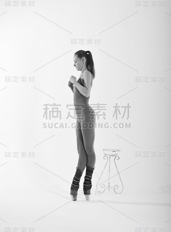 白色背景上穿着工装裤的芭蕾舞女演员