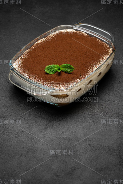 传统的意大利提拉米苏甜点在玻璃烤盘在混凝土背景
