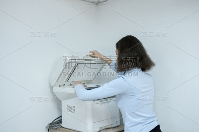 办公室，黑发女孩用打印机复印文件