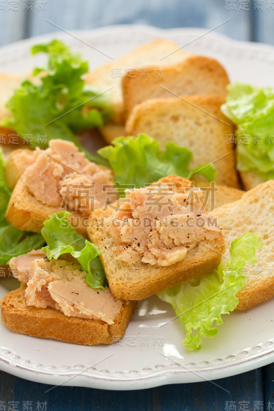 烤面包和肉酱放在白色的盘子里