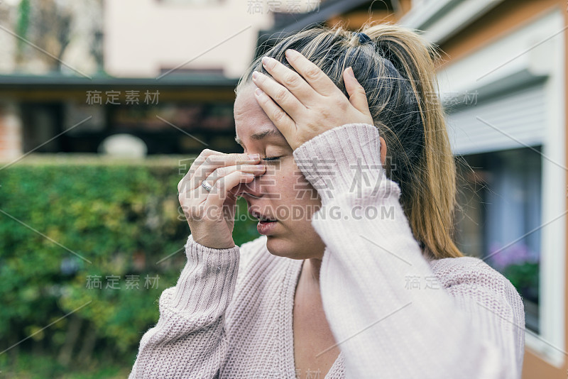 可怜的女人因为鼻窦疼痛而捂着鼻子和头