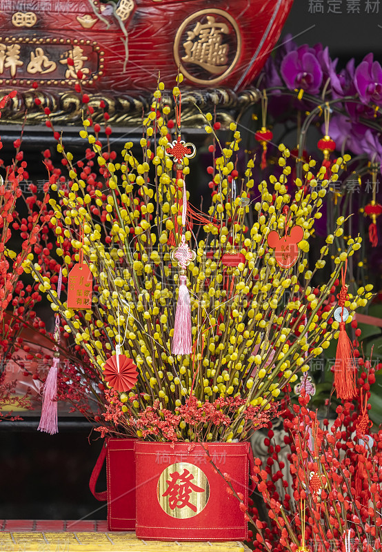 吉祥结悬挂在鲜花上表示新年的问候，汉字意味着新年的美好祝福