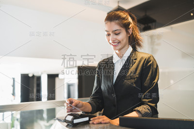 接待员在接待处给客人刷卡并收费。