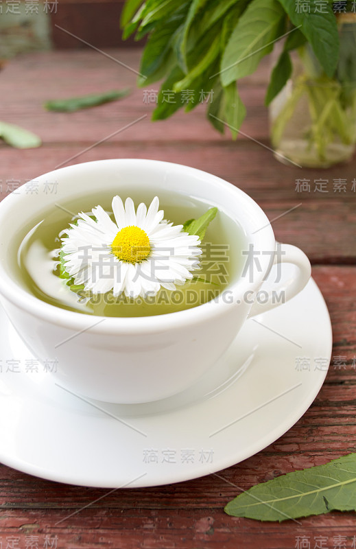 一杯含有野生甘菊、薄荷和鲜花的花草茶