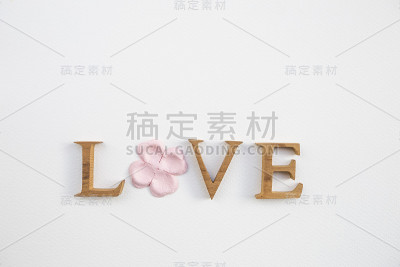 木爱字体与粉红色纸花与空间在白纸纹理背景