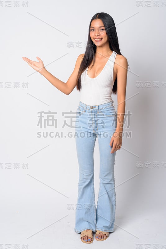 全身照片的快乐年轻美丽的亚洲女人显示一些东西