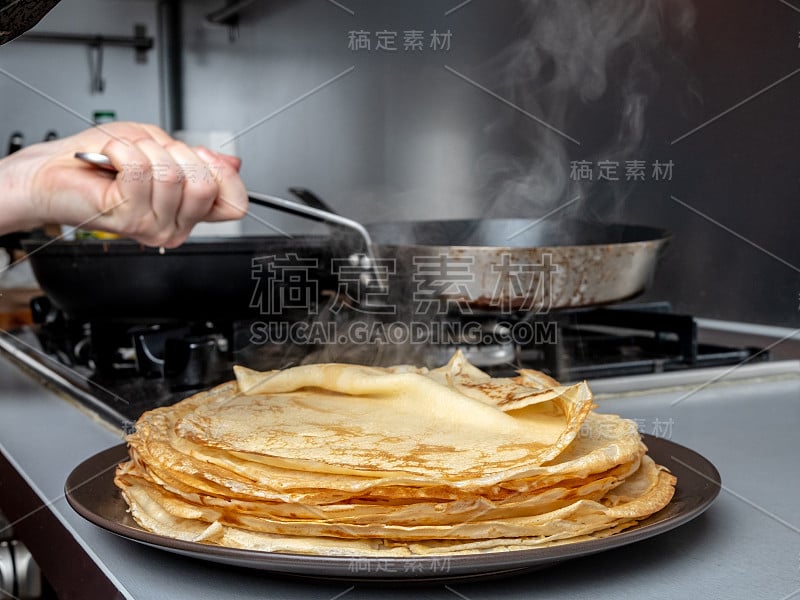 刚烤好的薄煎饼堆在热气腾腾的浅盘上。煎饼周的传统美食。