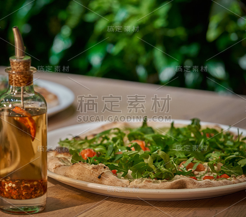 新鲜芝麻菜的素食披萨。绿墙植物背景