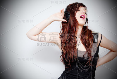 美丽的年轻女子听音乐耳机的生活理念