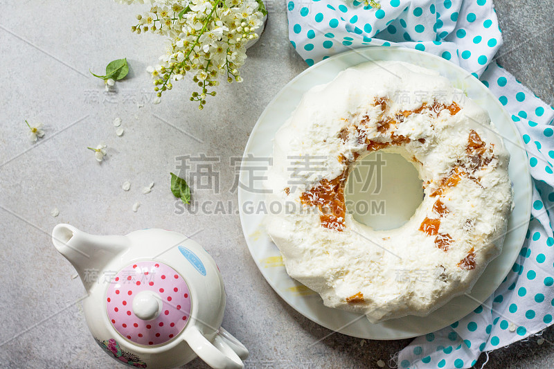 Pannacotta甜点。白软干酪蛋奶酥意式奶冻配杏子和椰子装饰在一块石头或石板上，放置在明亮的台面