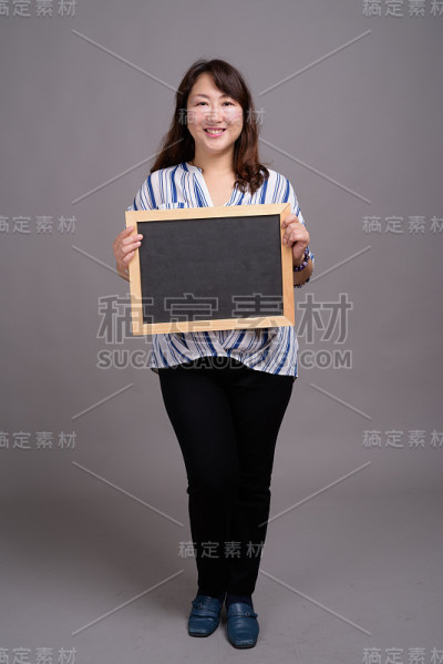 工作室拍摄的成熟美丽的亚洲女商人在灰色的背景