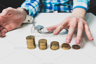 桌上有金币，那人解开袖口，伸手去拿金币。