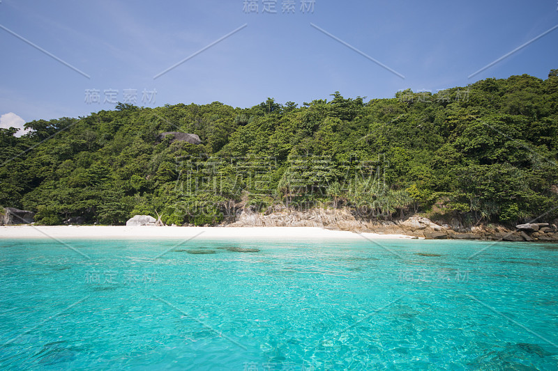 热带海滩，蓝天和平静的蓝色海浪