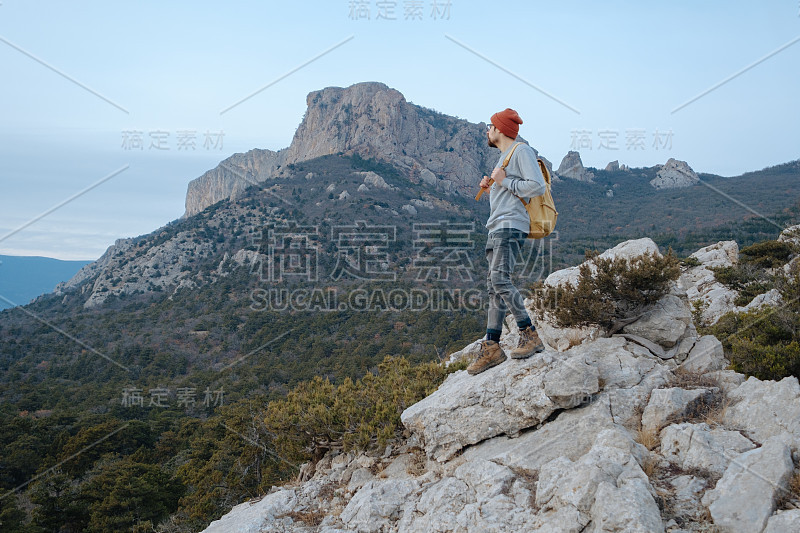 男人背包徒步旅行和红帽子在山区