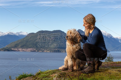 爱冒险的女孩带着狗在山顶徒步旅行