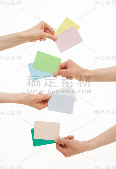 四只手拿着彩色的纸卡片