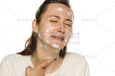 在白色背景上涂面霜的哭泣女人