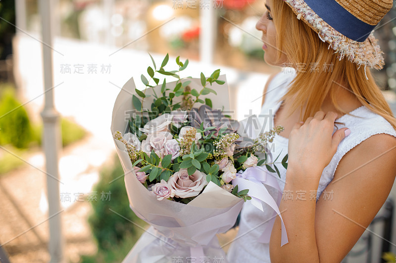 女性手持玫瑰、桉树和多肉植物的花束