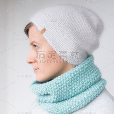 漂亮的年轻女子戴着一顶带绒球的帽子