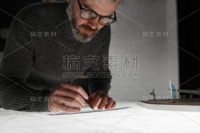 建筑师在办公室绘制蓝图。为建筑工程画草图的工程师。建筑计划。特写英俊的胡子男子集中工作。企业建设的概