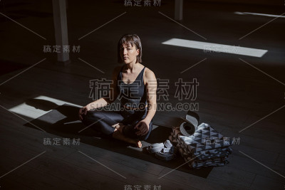 年轻平静的瑜伽女子莲花瑜伽姿势。瑜伽工作室内部。