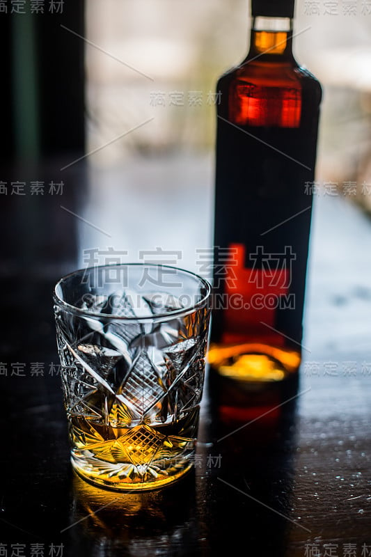 木质表面的威士忌酒杯和酒瓶