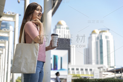 年轻漂亮的女人拿着一个白色的帆布包