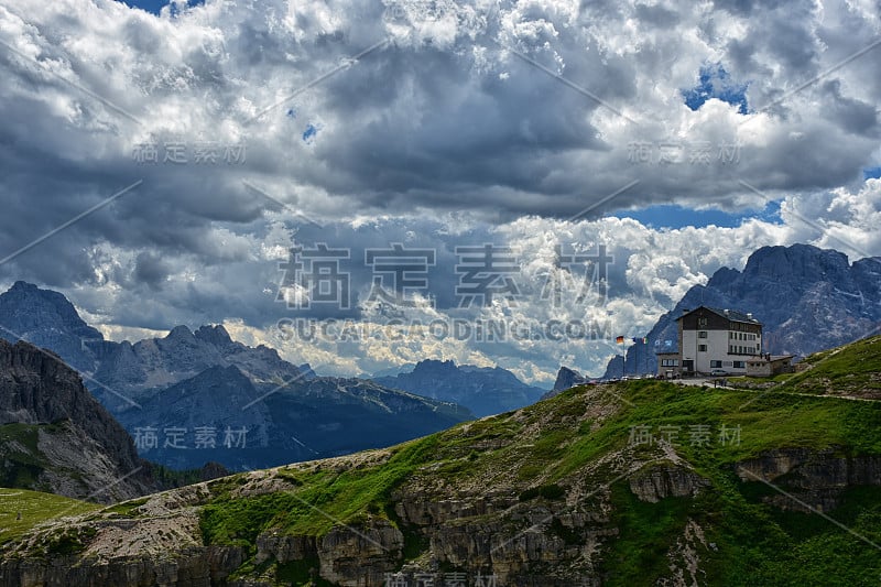 令人惊叹的风景，高山层和一个房子在一个多云的背景在春天