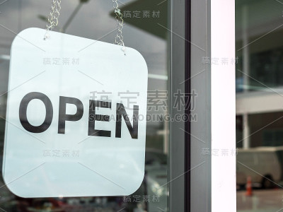 咖啡店的玻璃门上挂着白色的开放标志。