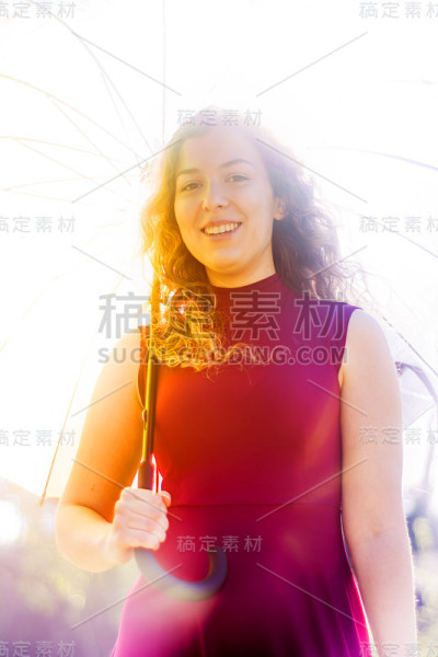 一个在阳光明媚的日子里打着伞的漂亮女人