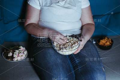 超重的女人坐在车上吃着垃圾食品