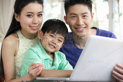 中国家庭坐在书桌前使用笔记本电脑