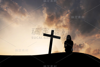 十字架和女人在山上日落的背景