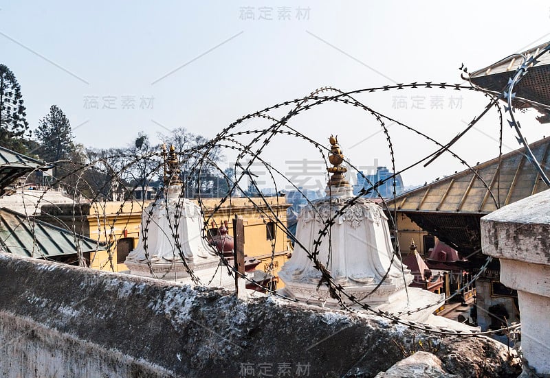 Pashupatinath建筑群周围的铁丝网，神圣的Bagmati河岸边的遗体火化，部分在2015年