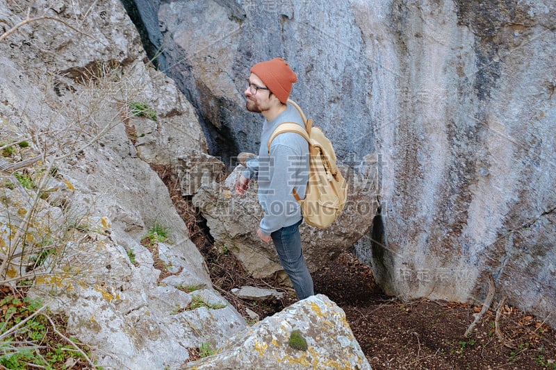 男人背包徒步旅行和红帽子在山区